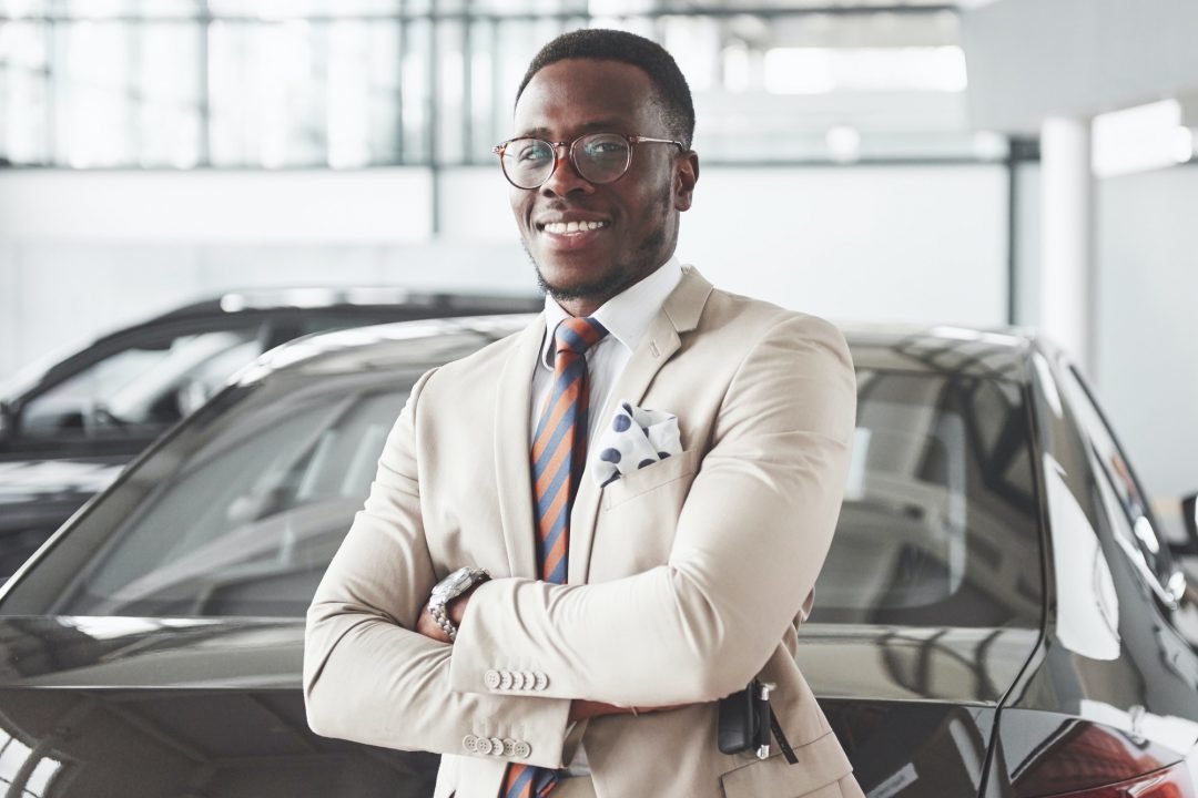 young black businessman on auto salon background car sale and rent concept 1